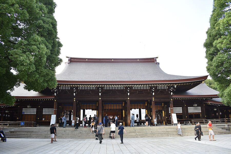The courtyard of Meiji Shrine showing the main worship hall and visitors in Tokyo
