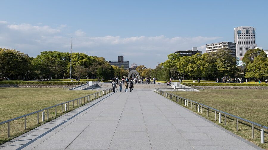 The Peace Memorial Park cenotaph in Hiroshima with the eternal flame and A-Bomb Dome aligned in the background