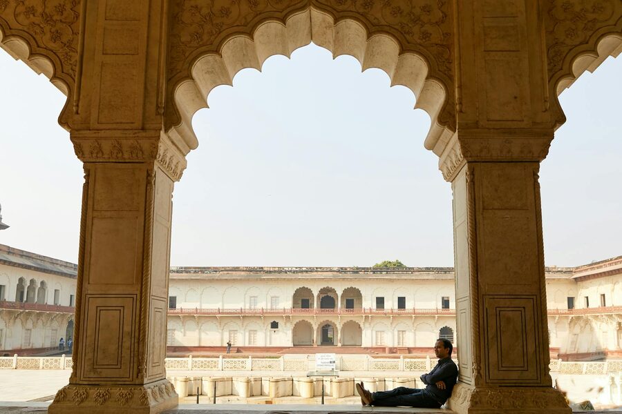 Man relaxing in arched corridor of Agra Fort