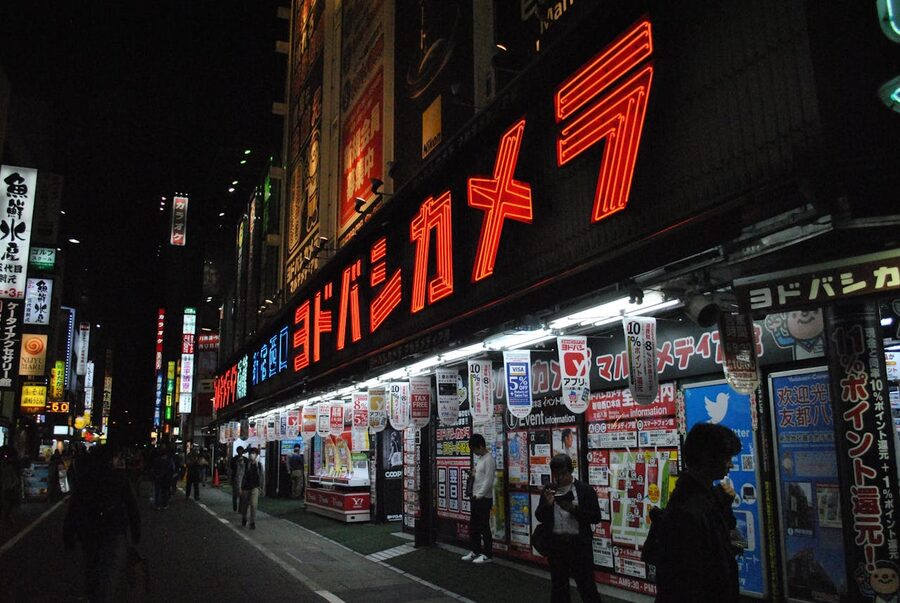Bright neon signs illuminating the streets of Akihabara at night