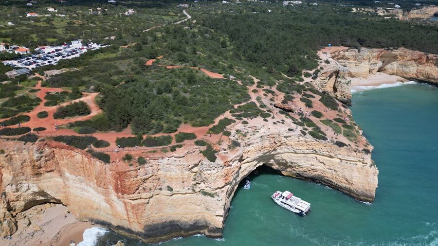 Aerial view of Algarve cliffs and coastline with boats at sea