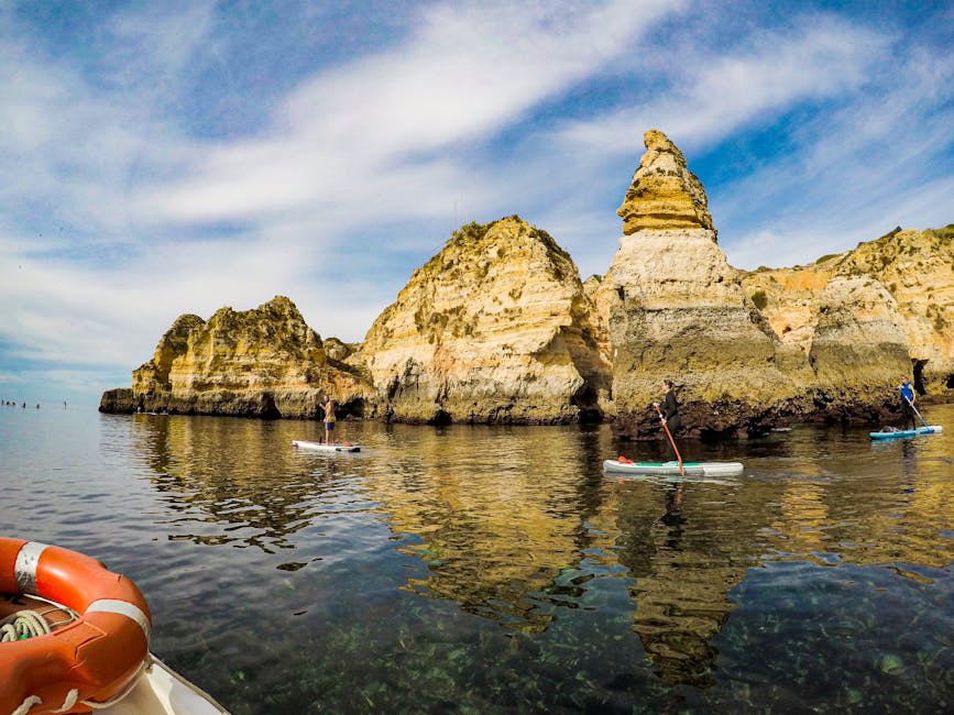 Paddleboarders at cliffs in Lagos, Portugal