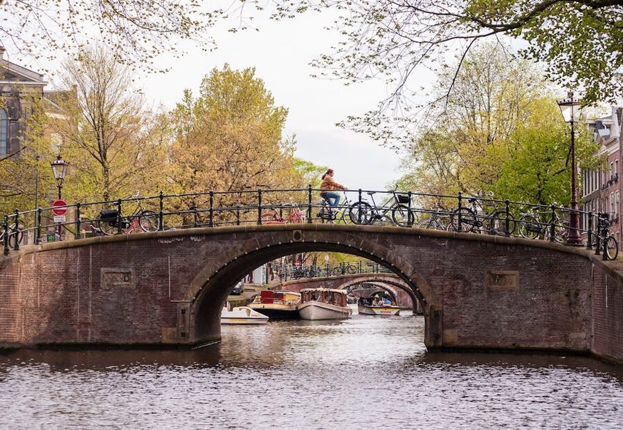 Cyclist on Amsterdam canal bridge