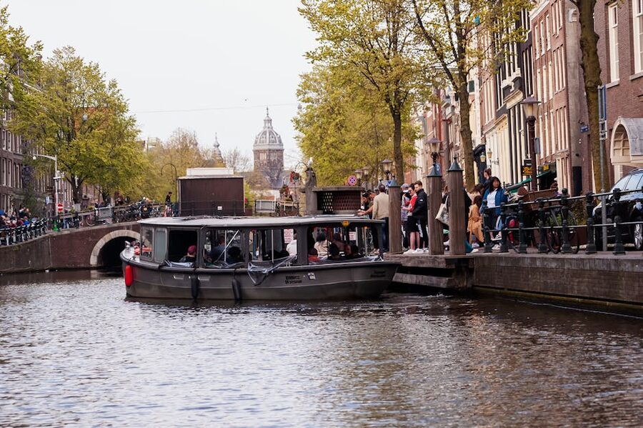 Amsterdam tour boat passes historic canal houses