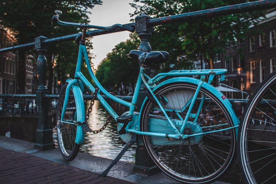 Blue bicycle parked on canal bridge in Amsterdam
