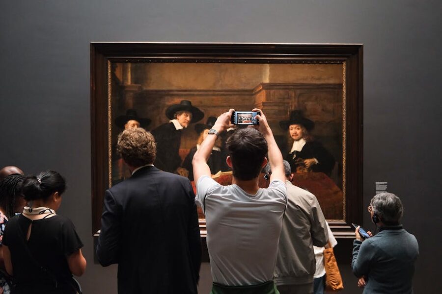 Visitors viewing classical painting at Rijksmuseum Amsterdam