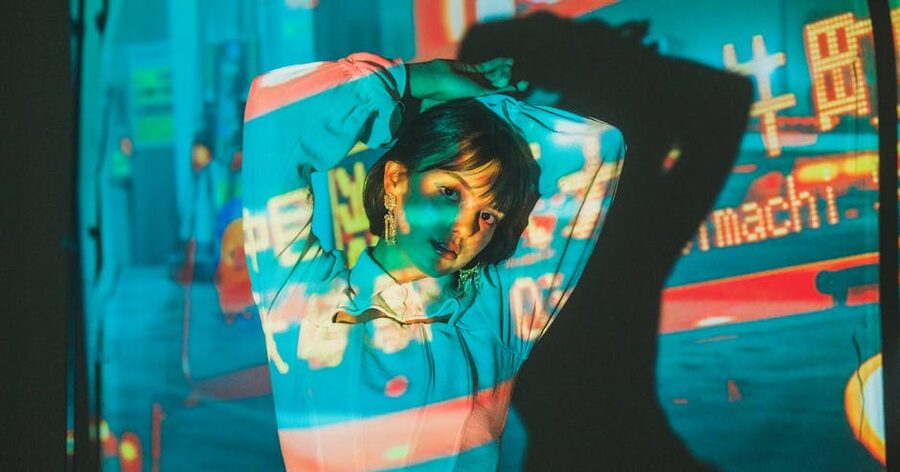 Person illuminated by colored projection lights inside Fabrique