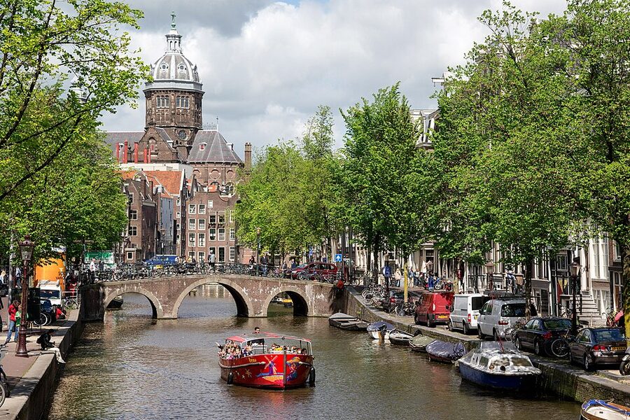 Glass-roofed canal tour boat in Amsterdam at a city dock
