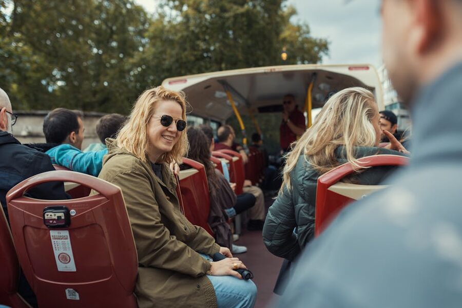 Tourists on an open-top hop-on hop-off bus during a city tour