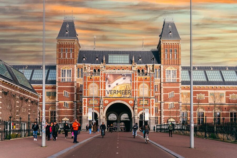Rijksmuseum entrance with people walking through the archway in Amsterdam