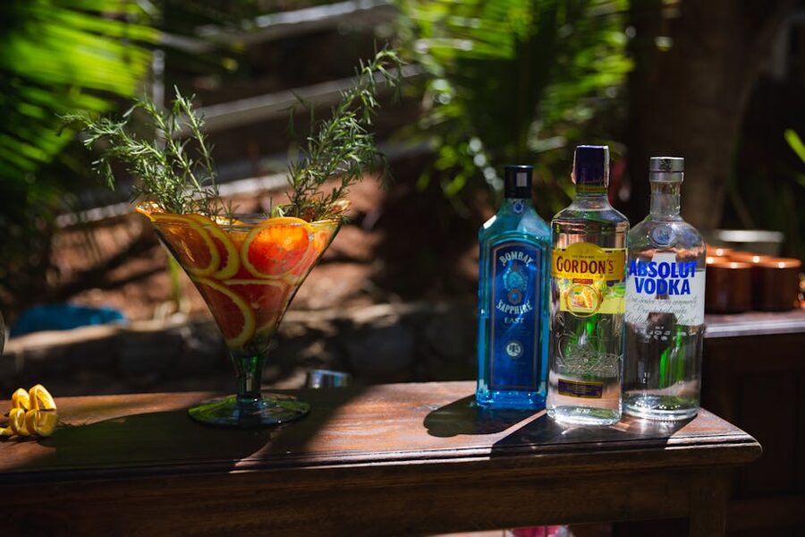 Citrus vodka cocktail next to bottles of clear spirits