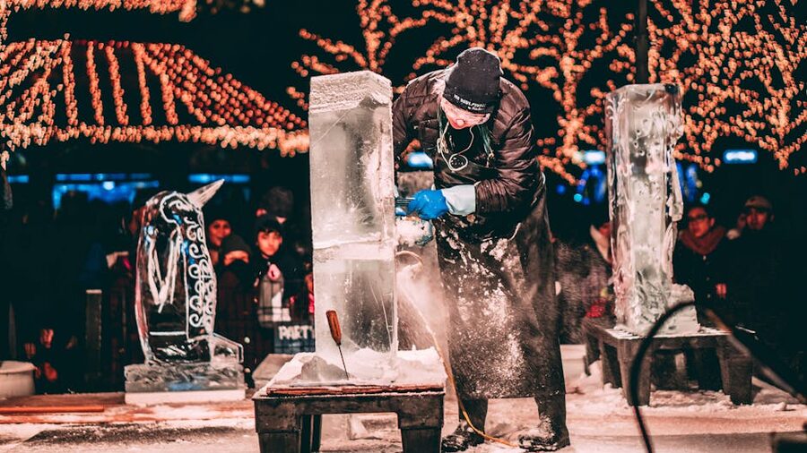 Ice sculptor carving a block of ice with chainsaw