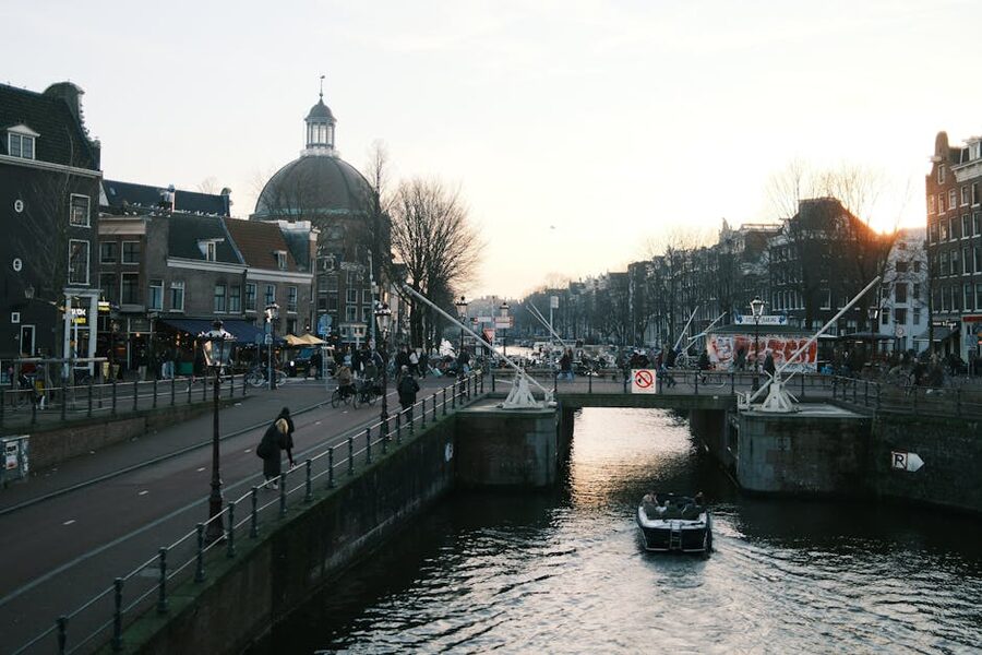 Amsterdam canal and bridge at sunset with boat