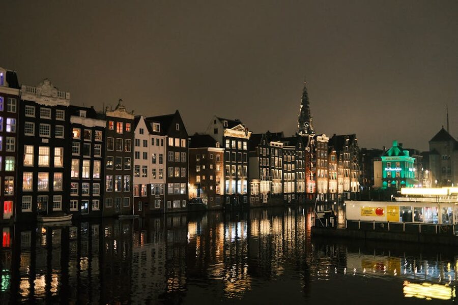 Amsterdam canal houses reflected in water at night