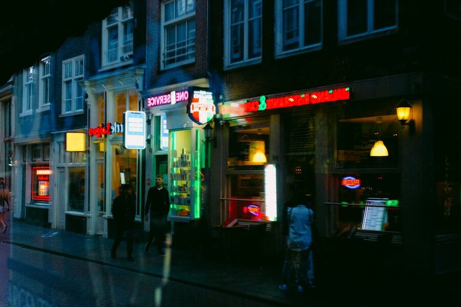 Neon-lit storefronts at night in Amsterdam