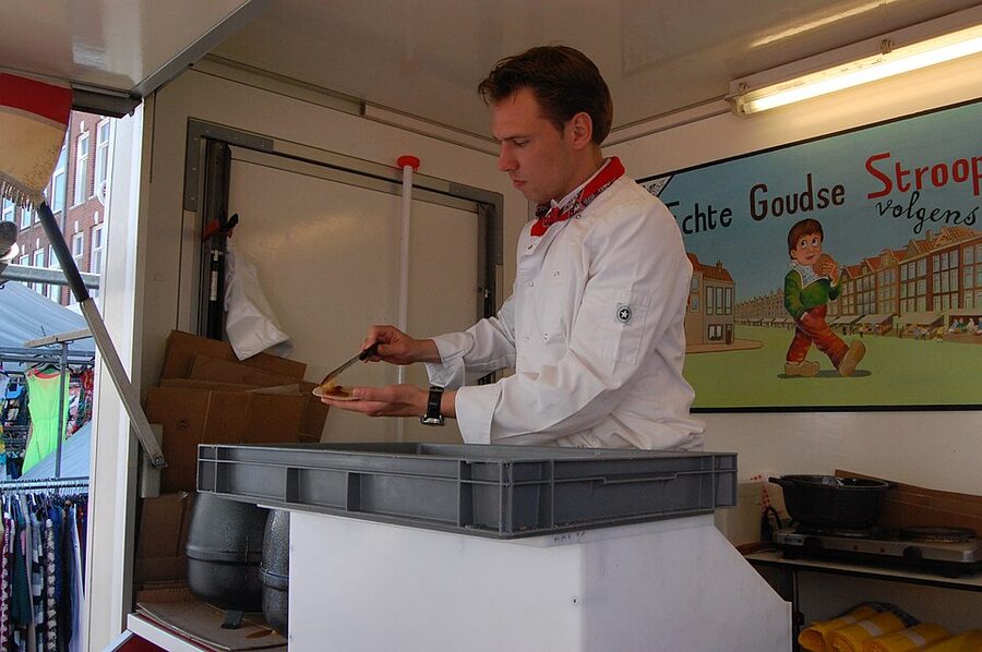 Pressing stroopwafel dough on the iron Amsterdam