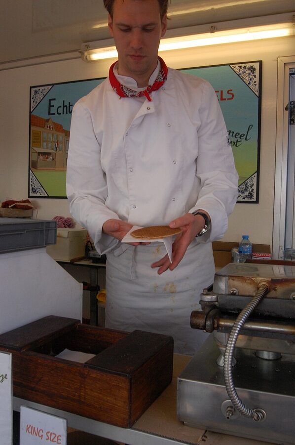 Pouring caramel syrup onto a fresh stroopwafel Amsterdam