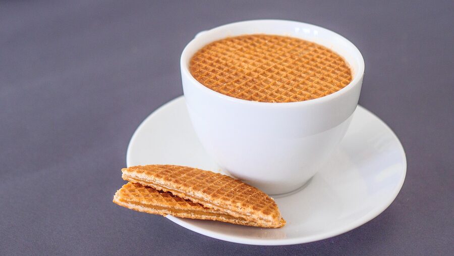 Stroopwafel resting on coffee cup with cinnamon