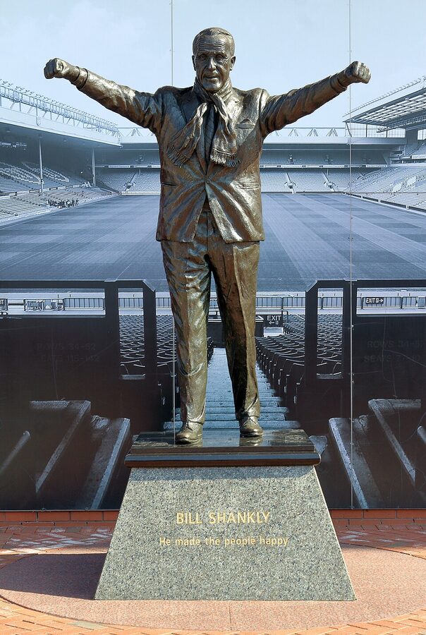 Bill Shankly statue at the front of Anfield stadium with arms raised