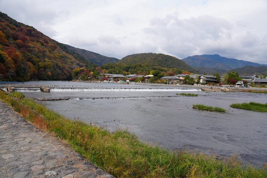 Scenic autumn view of Katsura River in Arashiyama with colorful foliage and mountains