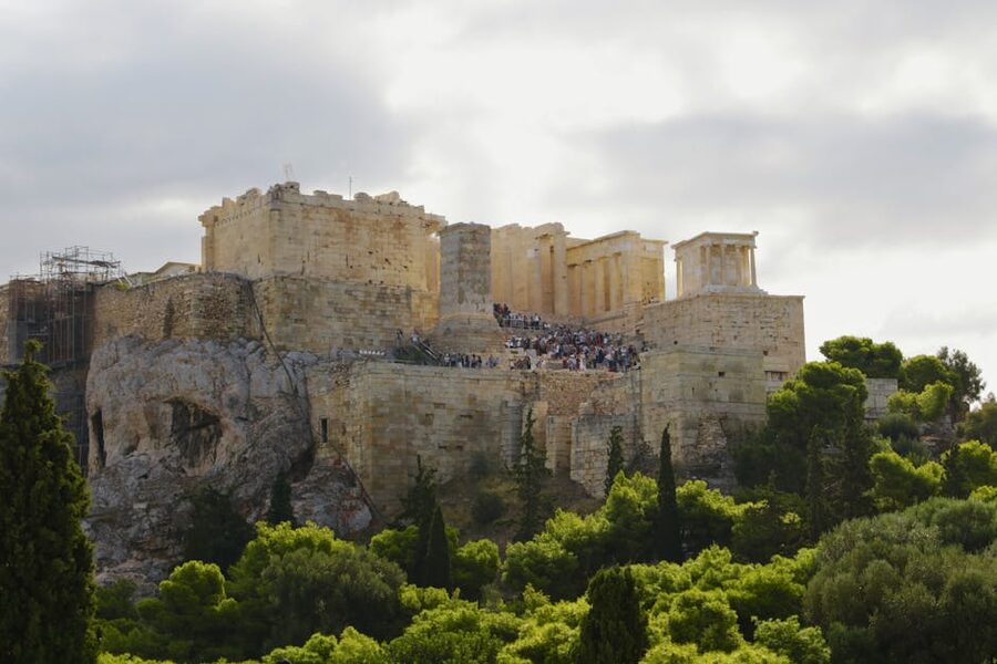 Acropolis of Athens surrounded by greenery in summer daylight