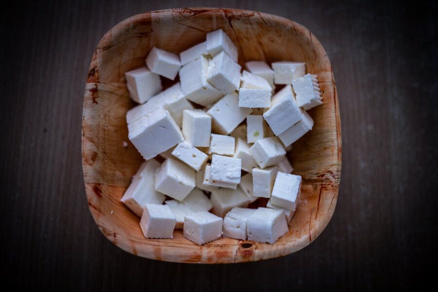 Fresh feta cheese cubes on a wooden bowl