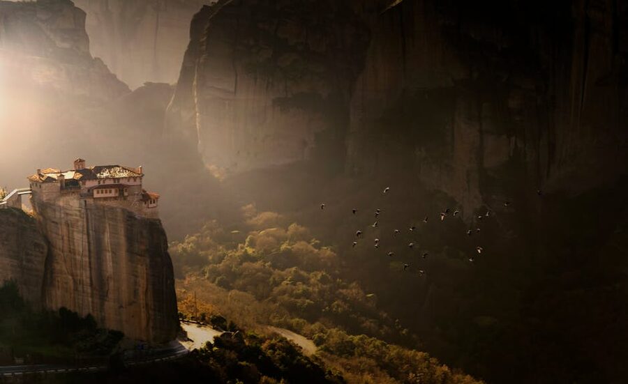 Meteora monastery on cliff at sunset Greece