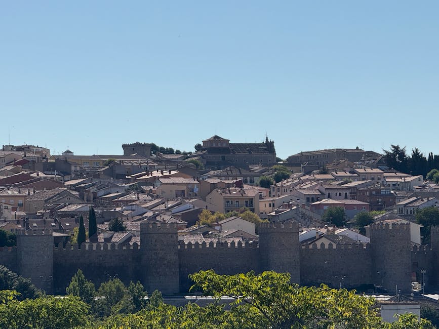 Panoramic view of Avila medieval walls under blue sky