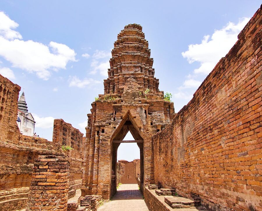 Weathered brick temple ruins with grass growing between stones at Ayutthaya Thailand