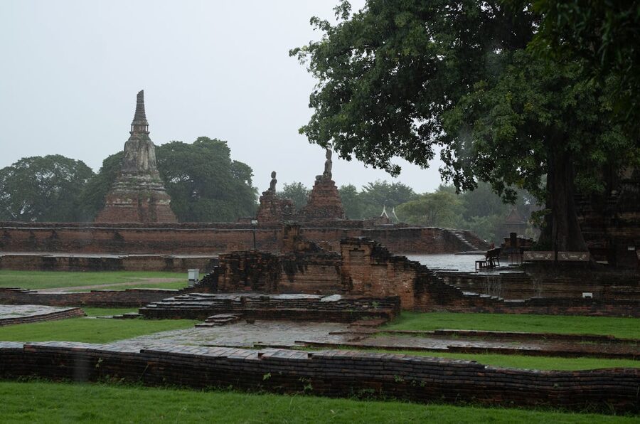 Ancient temple ruins in Ayutthaya during a tropical rain shower