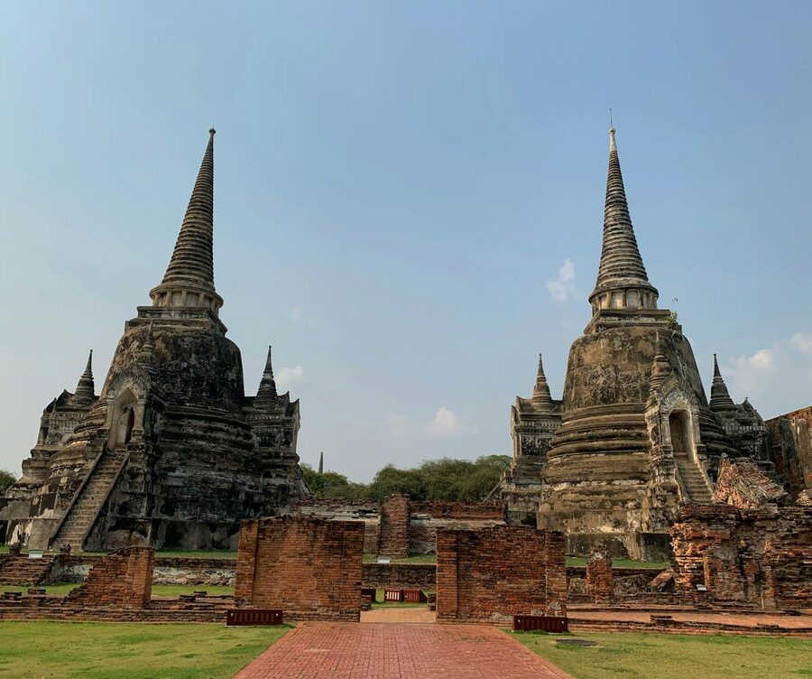 Three bell-shaped chedis of Wat Phra Si Sanphet standing against a bright sky in Ayutthaya