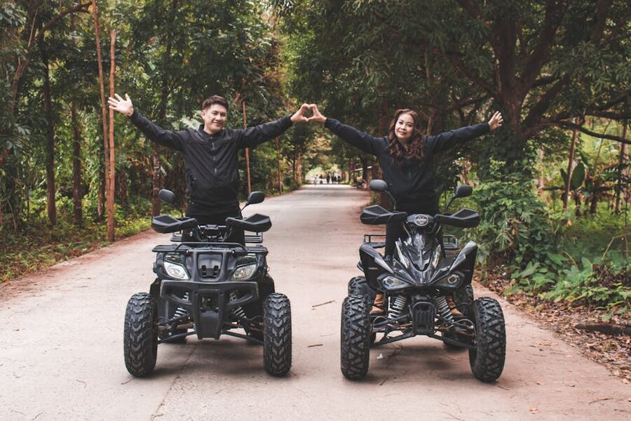 Couple riding quad bikes through a forest trail on a Bali ATV tour