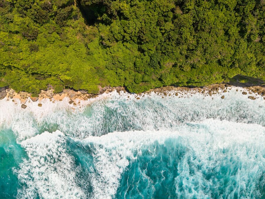 Jungle-covered cliff above a sheltered beach cove on the east coast of Bali
