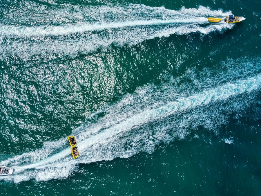 A Bali speedboat cutting across the ocean with wake trailing behind on the way to Nusa Penida