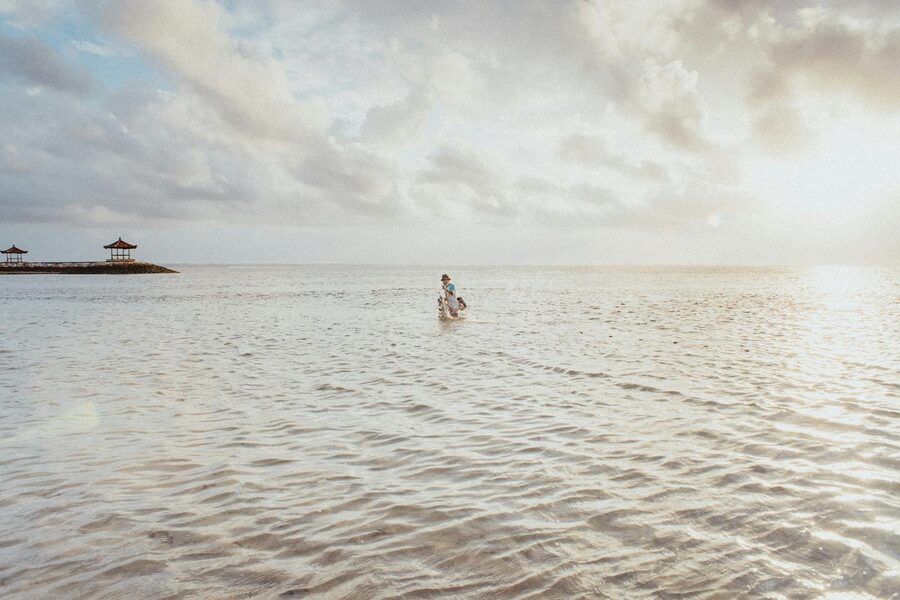 Soft pink and orange sunrise light over a beach in Bali