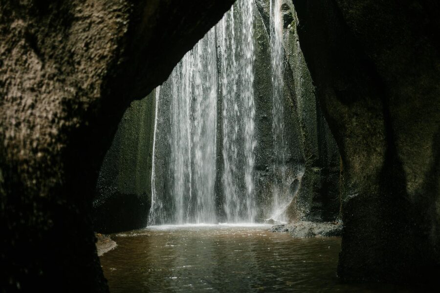 Mist rising from a Bali waterfall into morning sunlight