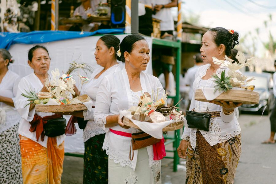Balinese women in traditional attire carrying ceremonial offerings