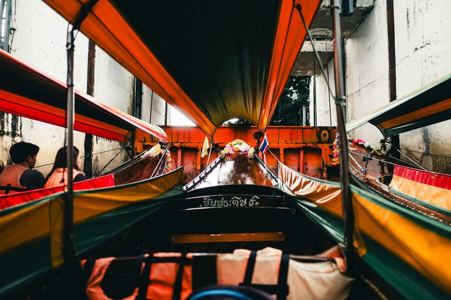 Longtail boat moving through a Bangkok klong with canal-side buildings