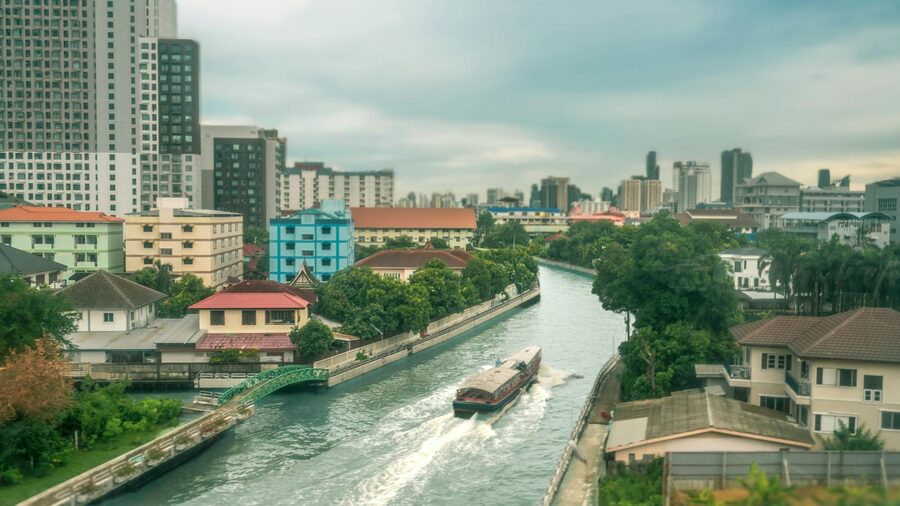 Calm canal view with small boat and colorful buildings in Bangkok