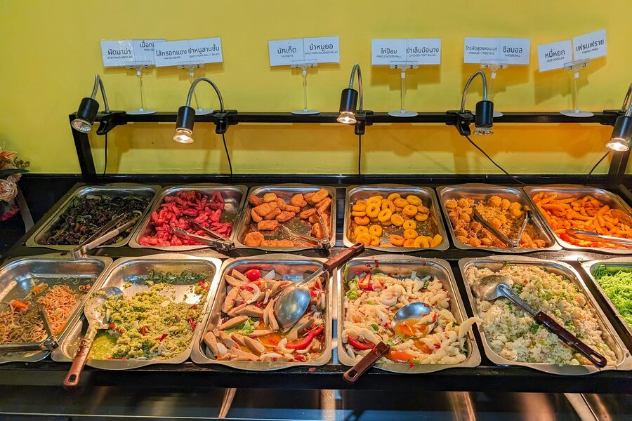 Colorful selection of Asian dishes displayed in buffet serving trays