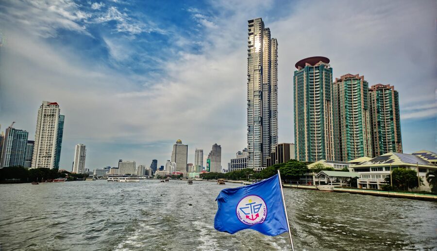View of Bangkok skyline with modern buildings from a ferry on the Chao Phraya River