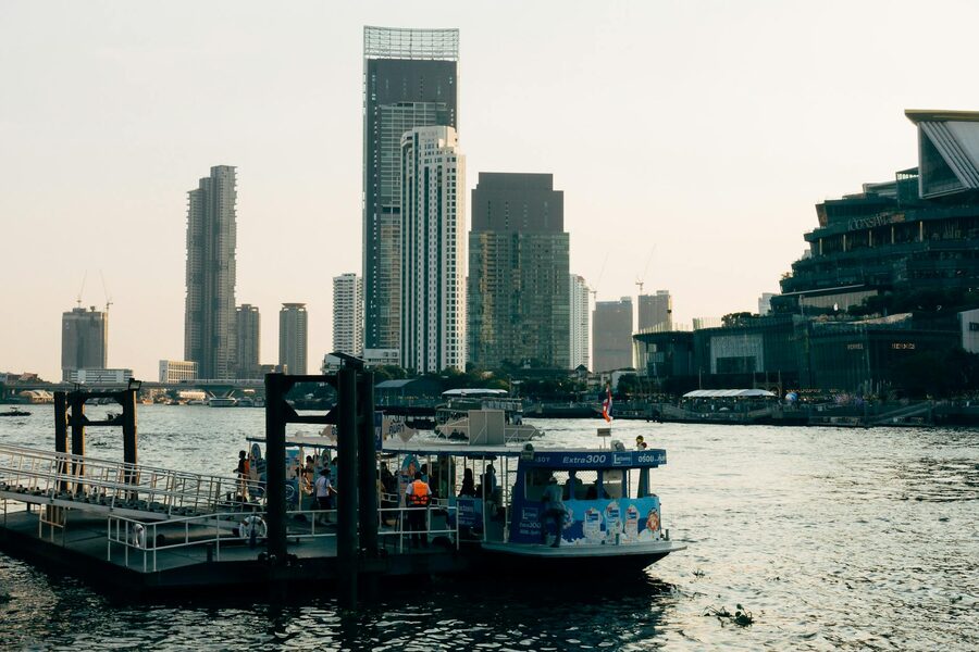 Bangkok skyline and waterfront at twilight with modern architecture and boats