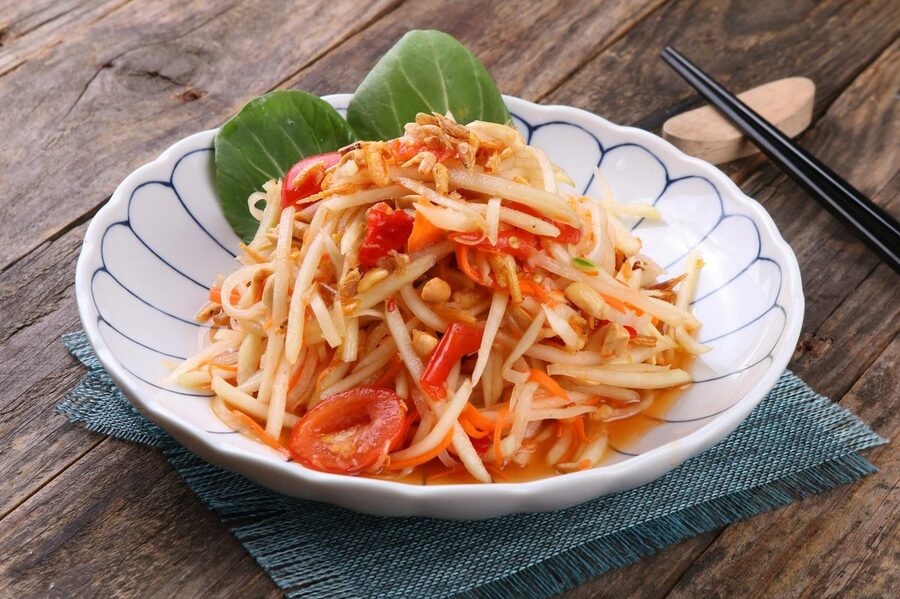 Thai green papaya salad Som Tam served with peanuts