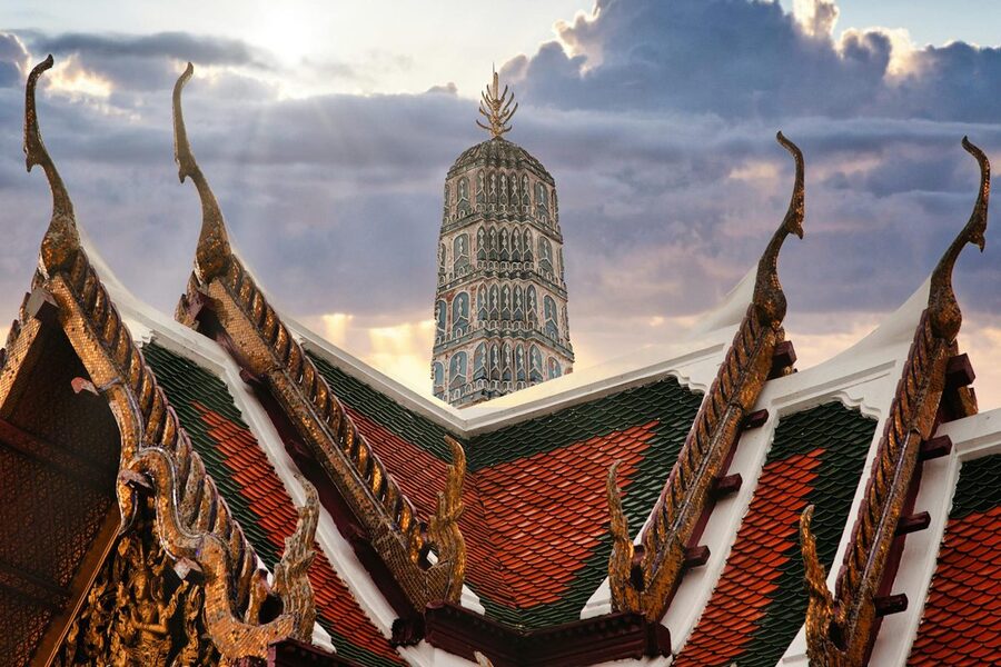 Traditional Thai rooftops with Wat Arun temple at sunset
