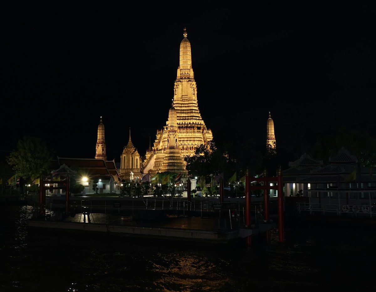 Wat Arun Temple lit up at night along the Chao Phraya River in Bangkok