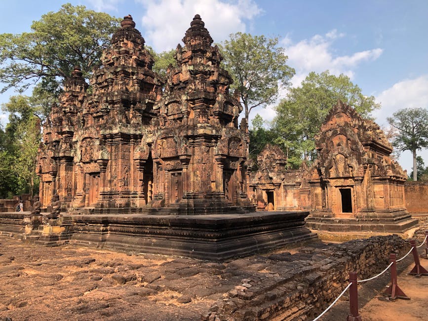 Intricate carvings at Banteay Srei temple amidst greenery