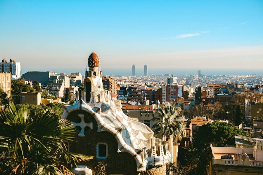 Aerial view of Park Güell mosaic terrace and Barcelona skyline