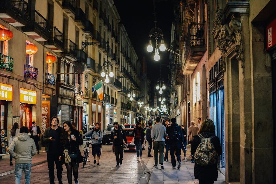 Barcelona old town nightlife with people walking under street lamps