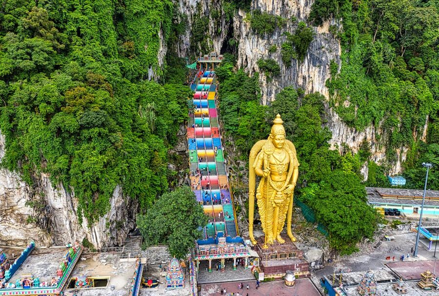 Aerial view of the Batu Caves complex with the golden Murugan statue and limestone hills