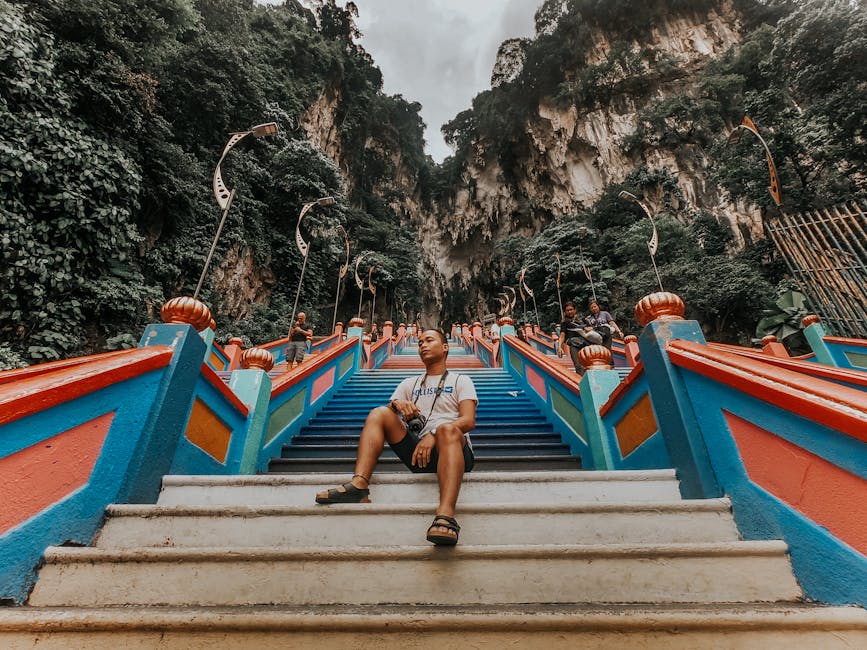 A visitor sitting on the colorful steps of Batu Caves